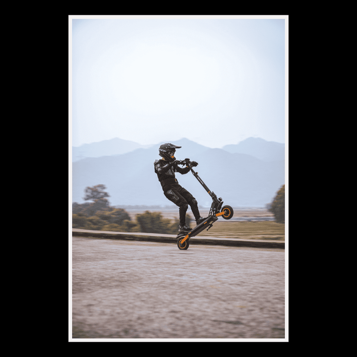 Person riding KUKIRIN G2 Pro electric scooter in urban environment performing a stunt.