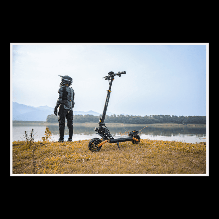 KUKIRIN G2 Pro electric scooter parked on grass with rider in safety gear near a lake.