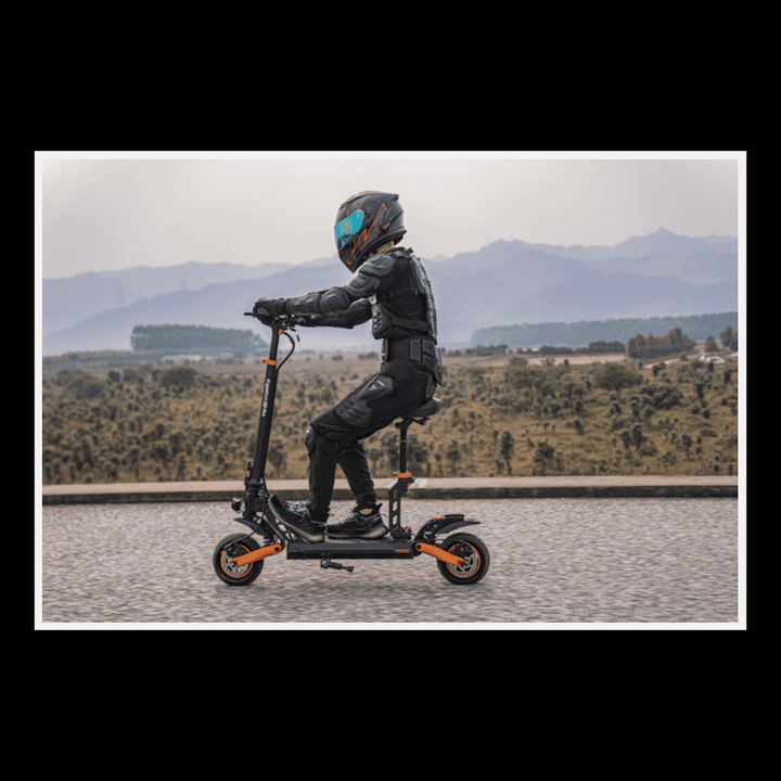 Person riding KUKIRIN G2 Pro electric scooter on a picturesque road with mountains in the background.