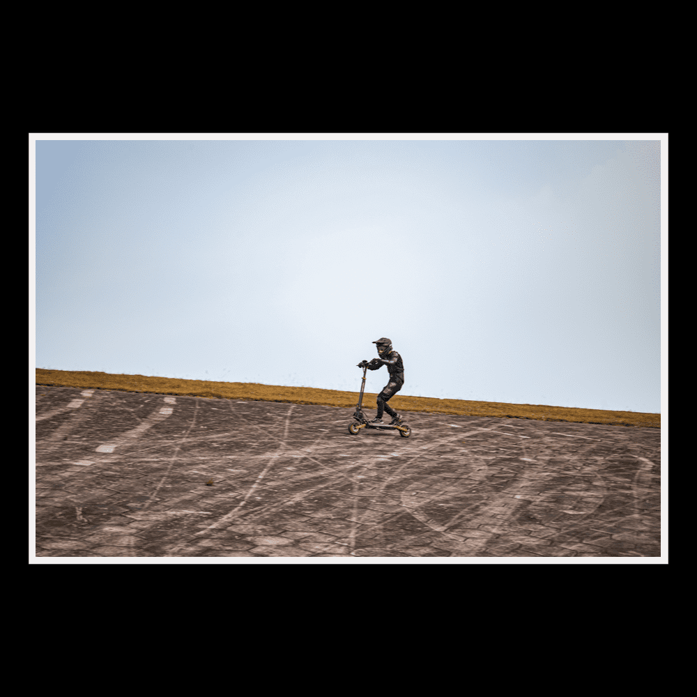 Rider enjoying the KUKIRIN G2 Pro electric scooter on an incline against a clear blue sky.