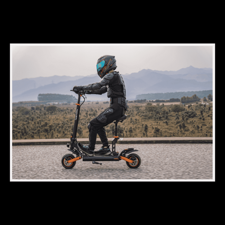 Person riding KUKIRIN G2 Pro electric scooter on a picturesque road with mountains in the background.