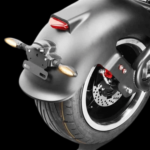 Rear view of the M1P electric chopper motorcycle showing tire and tail lights.