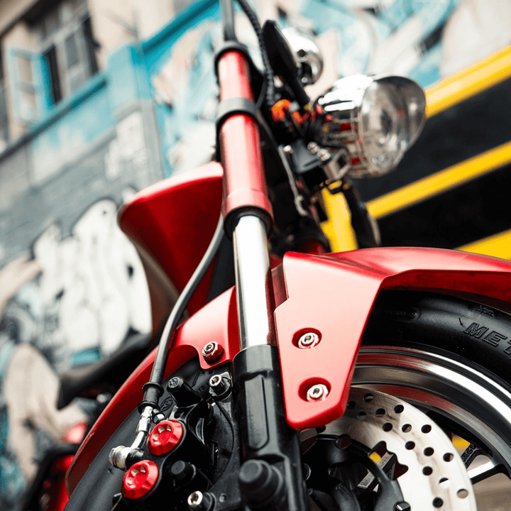 M1P electric chopper motorcycle close-up view showcasing the front fork and brake components.