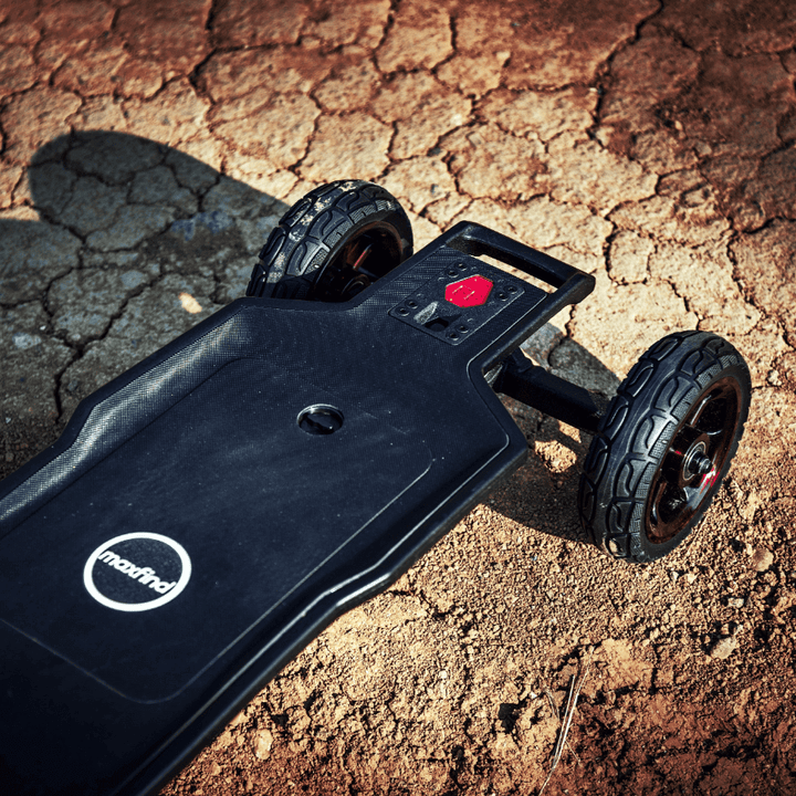 Maxfind FF AT electric skateboard on rough terrain showcasing its all-terrain capabilities and durable design.