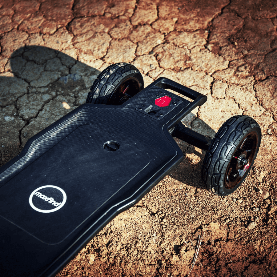Maxfind FF AT electric skateboard on rough terrain showcasing its all-terrain capabilities and durable design.