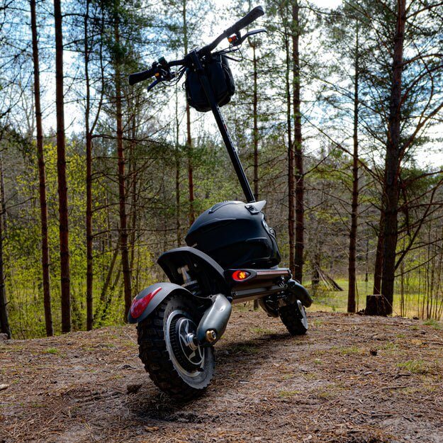 Nanrobot D6+ electric scooter parked on a trail with trees in the background, showcasing its rugged design and off-road capabilities.