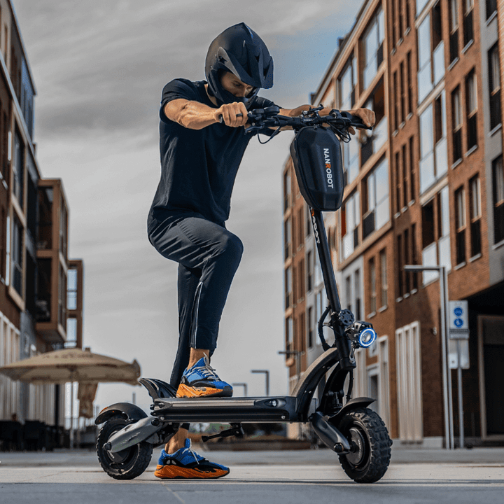 Man riding a Nanrobot D6+ electric scooter on city street demonstrating its features and performance.