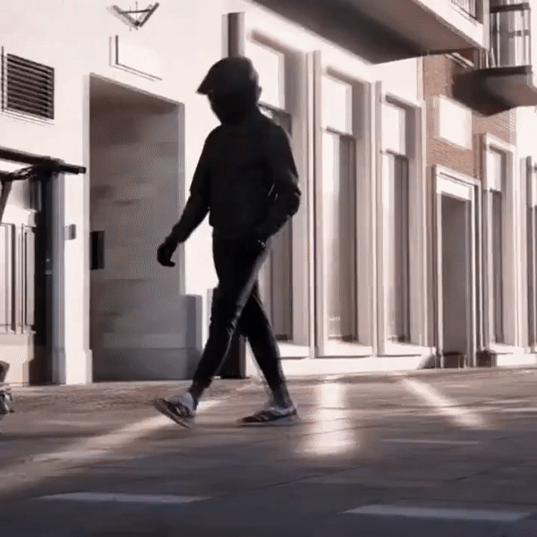 Nanrobot Lightning electric scooter rider walking on urban street, showcasing safety and style in e-scooter travel.