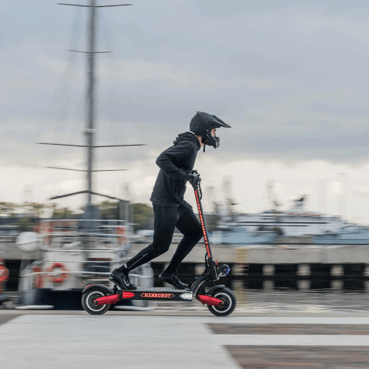 Person riding the Nanrobot LS7+ electric scooter at a harbor, showcasing its speed and dual-motor performance.