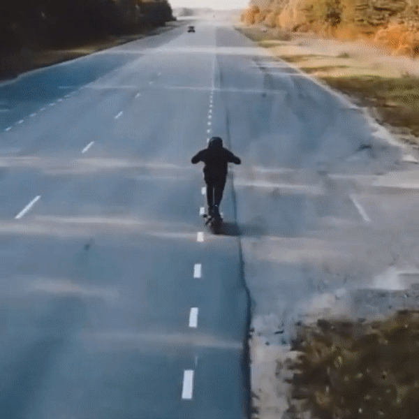 Person riding the Nanrobot LS7+ electric scooter on an empty road.
