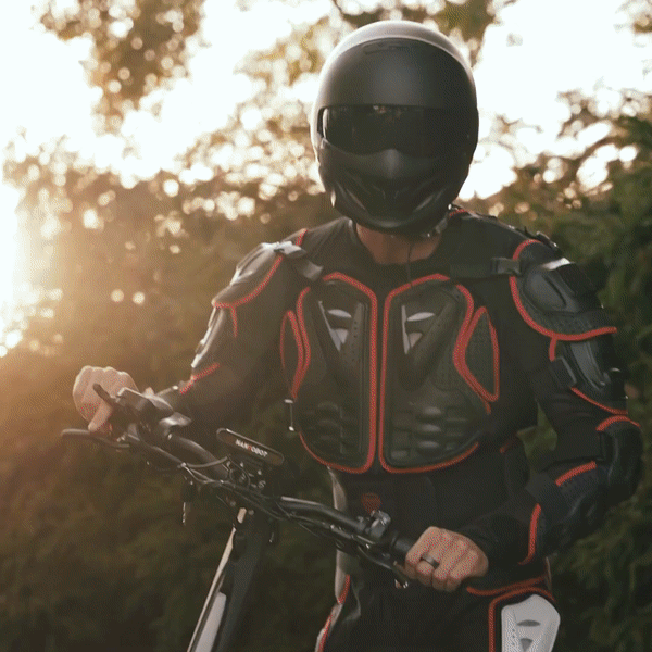 Rider in protective gear on NANROBOT N6 electric scooter against a sunset background.